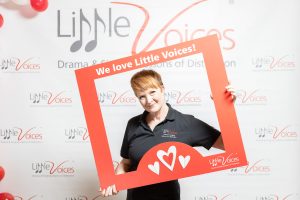 Photo of Little Voices franchisee holding up a photo frame that says 'We love Little Voices'