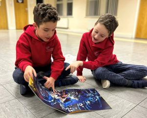 2 boys sitting on the floor collaborating, which helps develop their social-emotional skills